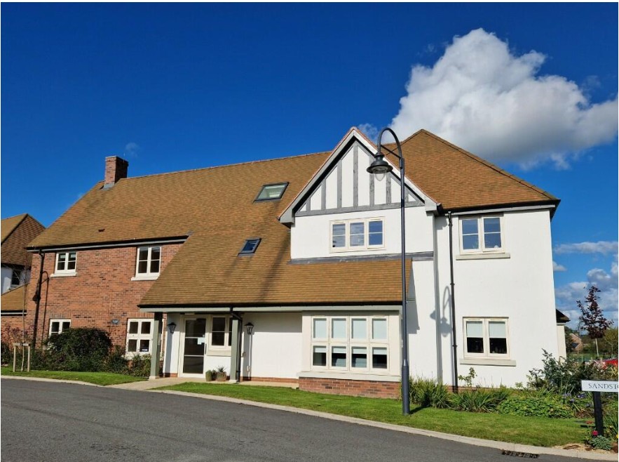 A beautifully designed modern home at 32 Pine Grove, featuring a combination of brick and white timber framing, a pitched roof, and large windows, set in a well-maintained residential area.