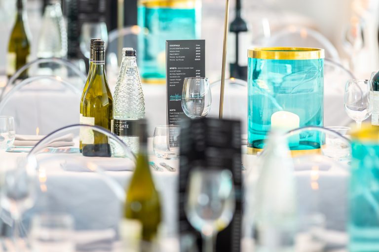 Hospitality set up containing table set up, glasses, wine and menus.