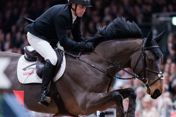 A powerful show jumping moment featuring FanFan-De-Beaufour, an elite competition horse, clearing an obstacle with its rider during a prestigious equestrian event. The focus is on the horse’s athleticism, strength, and precision in the show jumping arena.