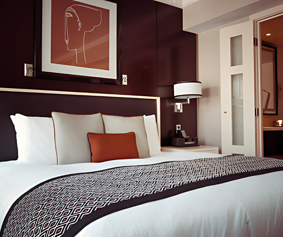 A stylish hotel bedroom featuring a plush king-size bed, modern lighting, and warm earthy tones, creating a luxurious and relaxing ambiance.
